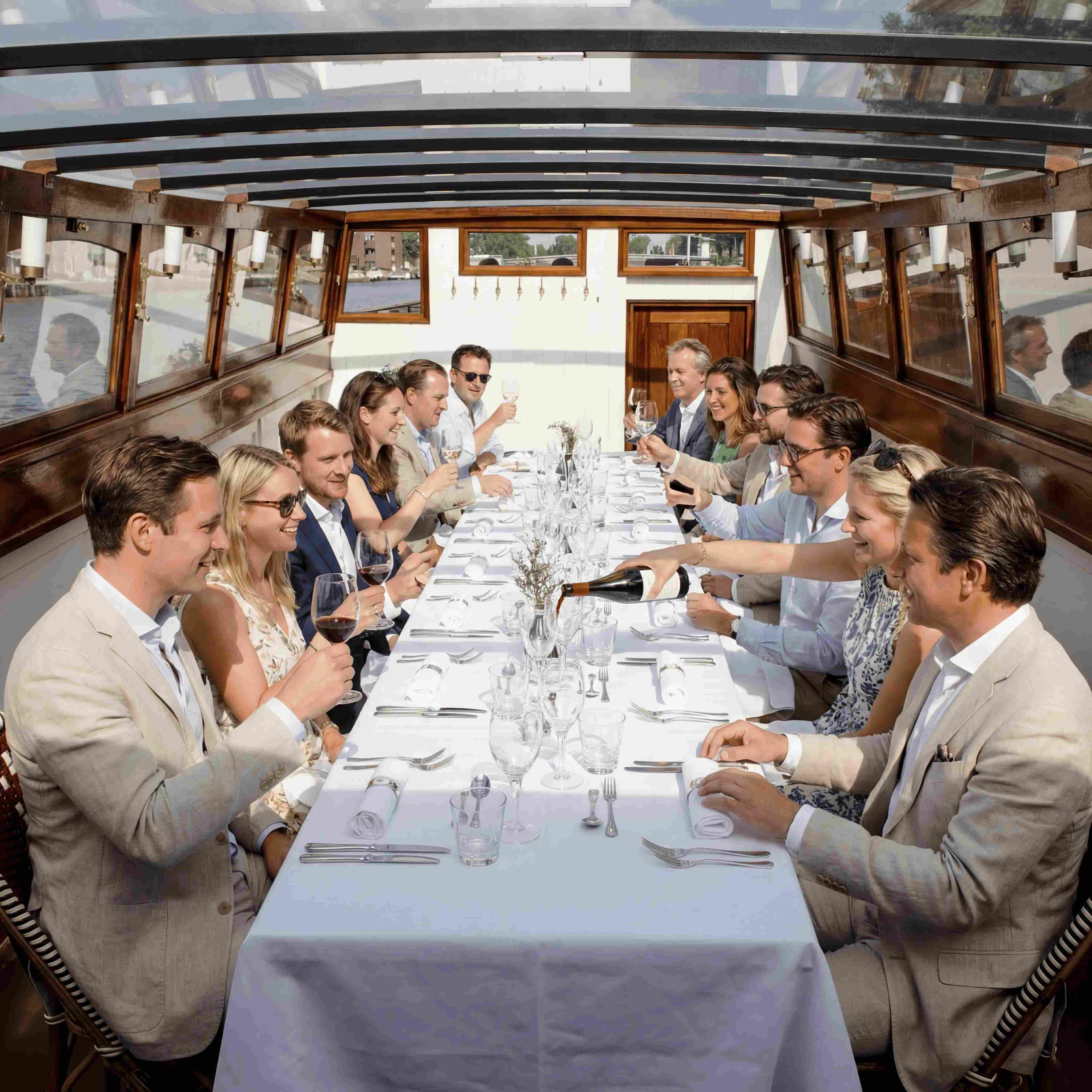 Guests dining at a festively laid table on a saloon boat
