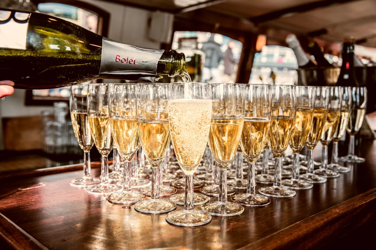 Champagne being poured into glasses aboard a saloon boat